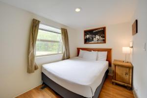 a small bedroom with a bed and a window at Pet-Friendly Hill Country Cabin with Shared Hot Tub! in Fredericksburg