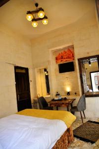 聖露法的住宿－karagül otel，一间卧室配有一张床、一张桌子和一张桌子
