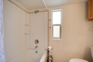 a white bathroom with a tub and a window at Cozy Fredericksburg Cabin with Shared Hot Tub! in Fredericksburg +29 photos