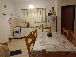 a kitchen with a table and chairs and a refrigerator at Cabañas Rincon Verde in Merlo