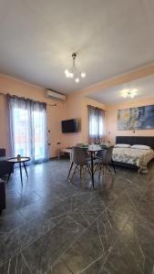 Habitación con cama, mesa y sillas. en Eretria Apartments EK9, en Eretria