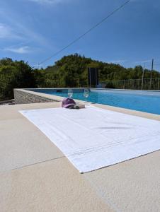 a table with a glass of wine next to a swimming pool at B&B with pool La Montaldina Piemonte in Spigno Monferrato