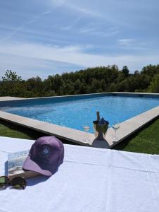 a hat and glasses on a table next to a swimming pool at B&B with pool La Montaldina Piemonte in Spigno Monferrato