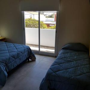 Schlafzimmer mit einem Bett und einer Glasschiebetür in der Unterkunft Dpto. San Luis Zona Shopping/centro in San Luis