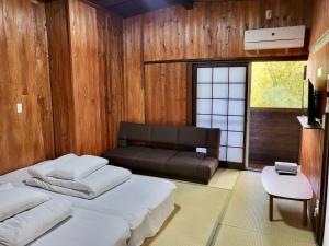 a bedroom with a bed and a couch in it at 旅館 竹屋 Takeya in Yufuin
