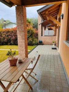 un patio con una mesa de madera y un banco en una casa en ,,,a casa di Martina en Mestre