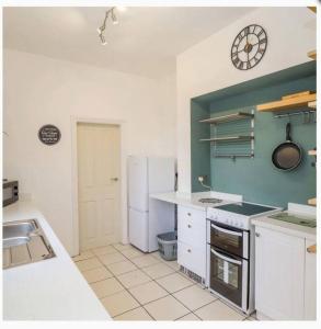 a kitchen with a sink and a clock on the wall at CoastGuard Cottage 3 Bed House Pet Friendly, Close to Spurn Contractors Welcome in Hull