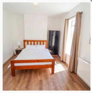 a bedroom with a bed and a wooden floor at CoastGuard Cottage 3 Bed House Pet Friendly, Close to Spurn Contractors Welcome in Hull
