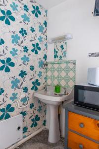 a bathroom with a sink and a flowery wallpaper at Penkerris in St. Agnes 