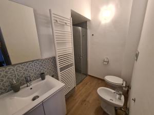 bagno bianco con lavandino e servizi igienici di Le stanze di Alicam ad Arona