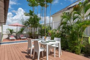 a white table and chairs on a patio with palm trees at The Gatehouse in Saint James