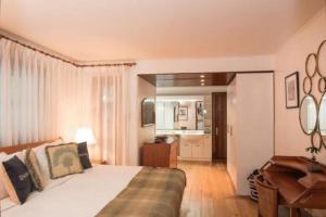 a bedroom with a bed and a desk and a kitchen at The Gatehouse in Saint James