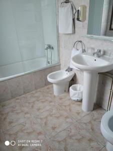 a bathroom with a sink and a toilet at Hostal Fisterra in Lugo