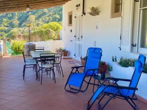 a patio with blue chairs and a table and chairs at Villa la Milanina in Lipari