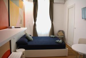 um pequeno quarto com uma cama azul e uma janela em Orti House Apartments - total renovation on Apr 2023 em Milão