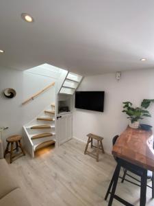 a living room with stairs and a tv and a table at SeaStay in Noordwijk