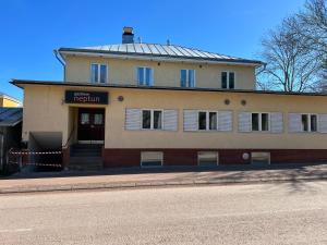 um edifício ao lado de uma rua com uma estrada em Gästhem Neptun em Mariehamn