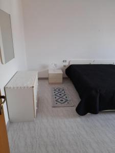 1 dormitorio con cama negra y mesa en Casa Sant' Antioco, en SantʼAntìoco