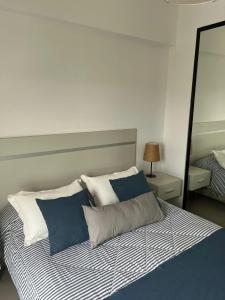 um quarto com uma cama com almofadas azuis e brancas em DEPTO CON INCREIBLE VISTA!! Y UBICACION!! em Salta