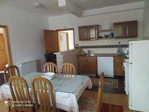 a kitchen with a table and chairs and a refrigerator at Apartman Ilidža in Kovači