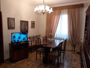 una sala da pranzo con tavolo e TV di Magdeleine Village ad Almagro
