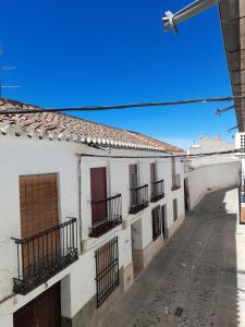 un callejón con edificios blancos y un cielo azul en Magdeleine Village, en Almagro