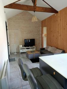 a living room with a couch and a tv at T3 refait à neuf, patio, wifi et plage in Arcachon