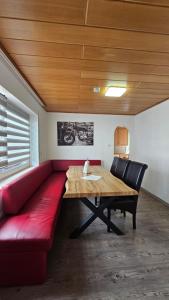 ein rotes Sofa und ein Holztisch in einem Zimmer in der Unterkunft Haus Mitten in Herzen von Günzburg in Günzburg