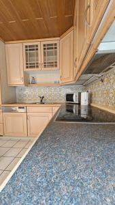 une cuisine avec des armoires en bois et un comptoir dans l'établissement Haus Mitten in Herzen von Günzburg, à Guntzbourg