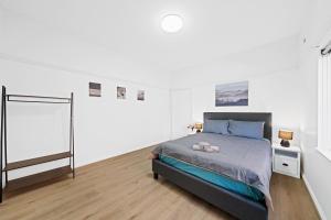 una camera bianca con un letto di Burwood City Newly renovated 2 Bed 2 Bath Free Private Parking Big Apt a Sydney