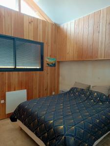 a bedroom with a bed and wooden walls at T3 refait à neuf, patio, wifi et plage in Arcachon