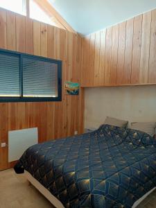 a bedroom with a bed and wooden walls at T3 refait à neuf, patio, wifi et plage in Arcachon