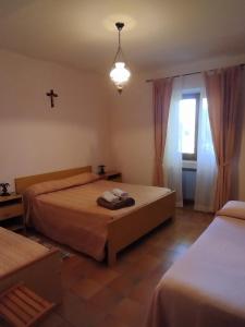 1 dormitorio con 2 camas y una cruz en la pared en Agriturismo Masseria Testa Ciruglio en Ielsi