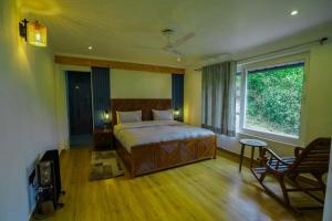 una camera con un grande letto e una finestra di The Apricity Bhimtal a Bhimtal