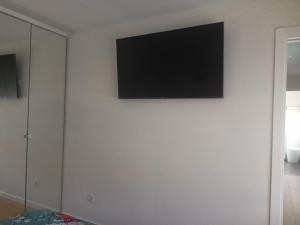 a flat screen tv on a white wall in a room at Ideal parejas in Moaña