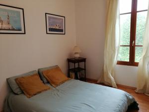 a bedroom with a bed and a window at La Campagne en Ville in Laragne