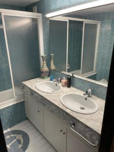 サン・フェリウ・デ・ギホルスにある1ra Linea Platja de Sant Feliuのバスルーム(洗面台2台、鏡付)