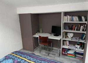 a bed room with a desk with a computer and a book shelf at Joli duplex en centre ville de 40m2 climatisé in Istres