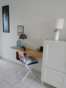 einen Schreibtisch in einem Zimmer mit einem Stuhl und einer Lampe in der Unterkunft Studio Golfe Juan, plages, parking, climatisation in Vallauris