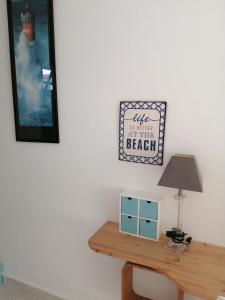 a table with a lamp and a picture on the wall at Studio Golfe Juan, plages, parking, climatisation in Vallauris
