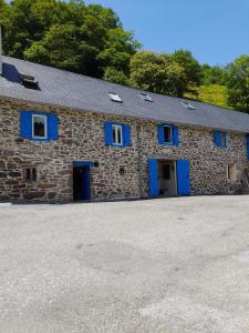un edificio de piedra con puertas y ventanas azules en Maison de montagne, en Borce