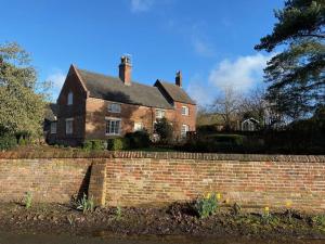 an old brick house with a brick wall at Boothorpe Farmhouse in Blackfordby