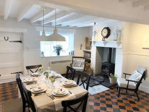 uma sala de jantar com uma mesa com cadeiras e uma lareira em Boothorpe Farmhouse em Blackfordby