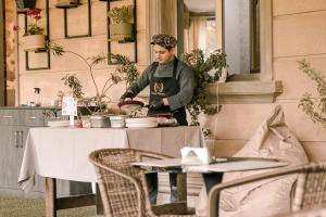 een man die eten bereidt aan een tafel in een restaurant bij Grand Hotel Baku Central Park in Baku