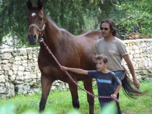 Un uomo e un ragazzo che conducono un cavallo marrone di pigeonnier-four à pain a Cazals