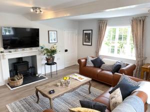 uma sala de estar com um sofá e uma mesa em Boothorpe Farmhouse em Blackfordby