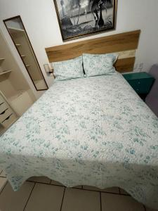 um quarto com uma cama com um edredão azul e branco em Linda Casa frente mar, pé na areia, Itapema SC, Ar, Wi-fi, Smart Tv em Itapema