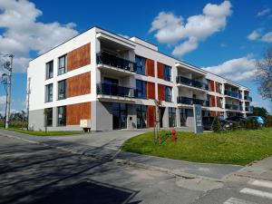 ein Apartmenthaus in einer Straße mit einem roten Hydranten in der Unterkunft Nowoczesne apartamenty Jezioro Ukiel Zatoka Miła Plaża Miejska in Olsztyn