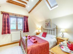 - une chambre avec un lit et une couverture rouge dans l'établissement The Lodge, à Lydney