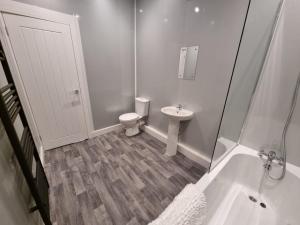 a white bathroom with a toilet and a sink at Manchester St by Prestige Properties SA in Barrow in Furness